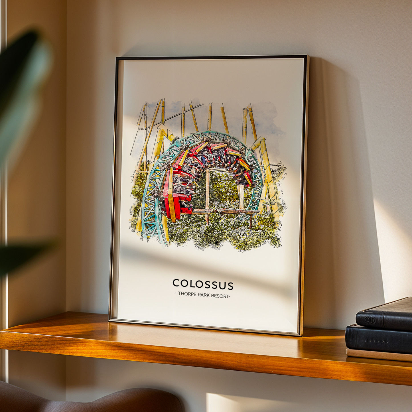 Framed artwork titled 'Colossus' on a shelf with books and a plant.
