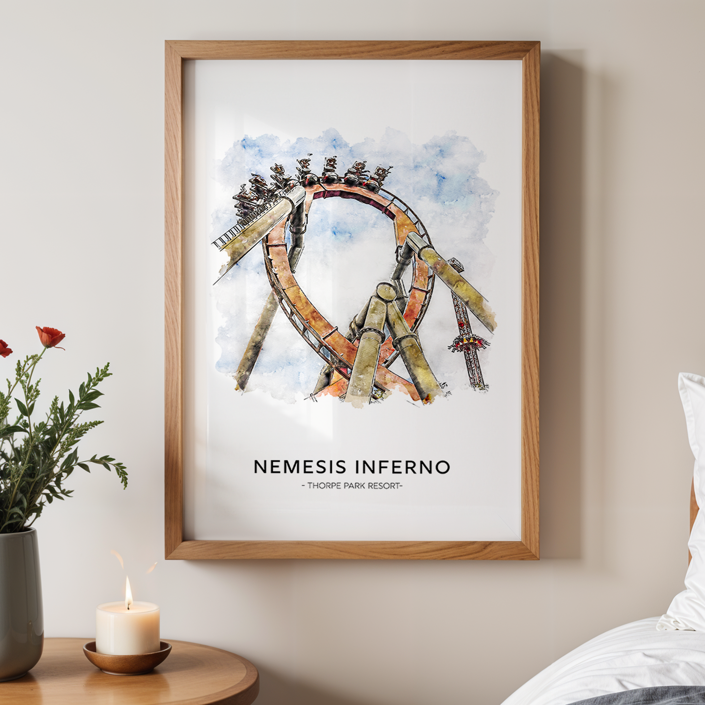 Framed artwork titled 'Nemesis Inferno' on a wall above a bed with a vase of flowers and candle.