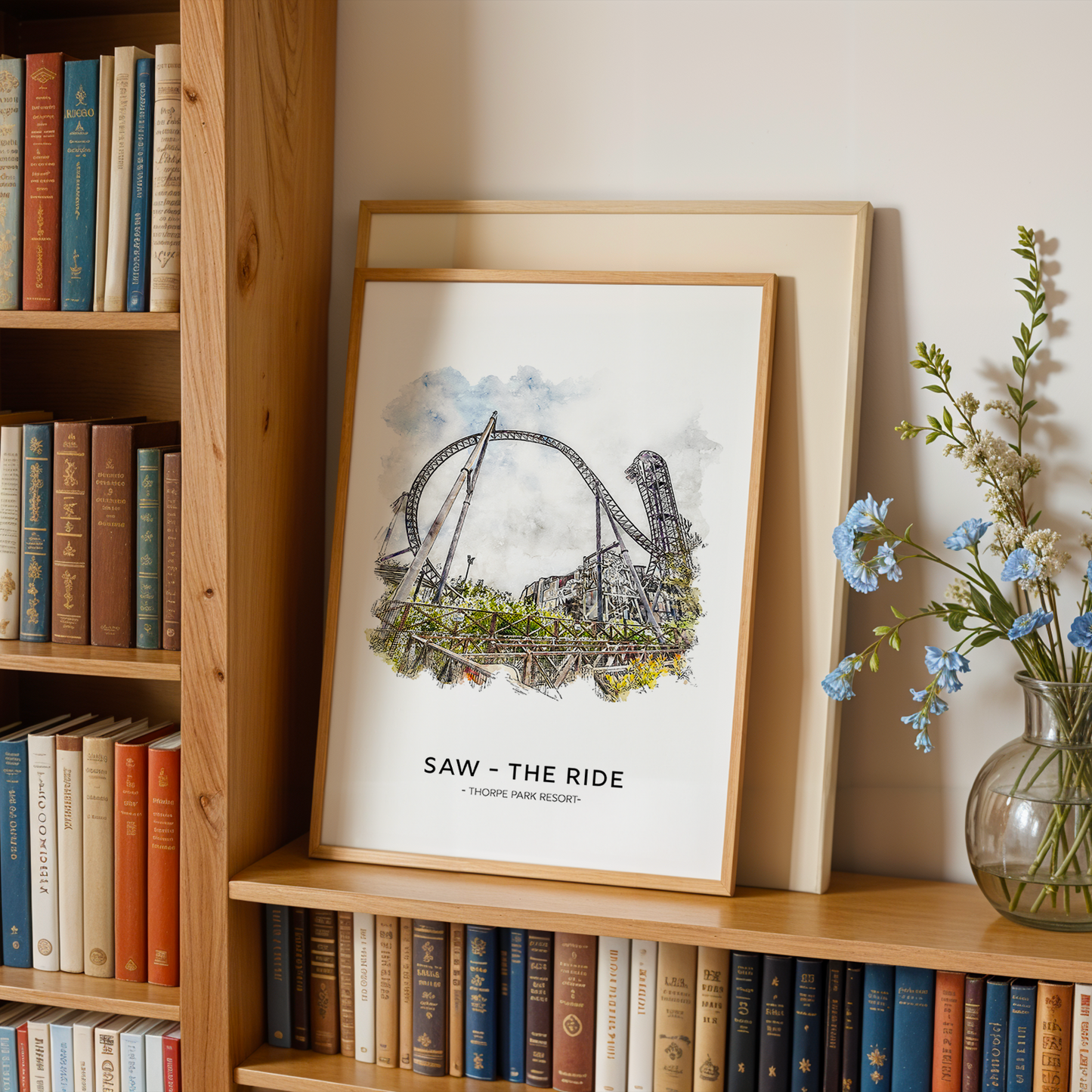 Framed artwork on a bookshelf with books and a vase of flowers.